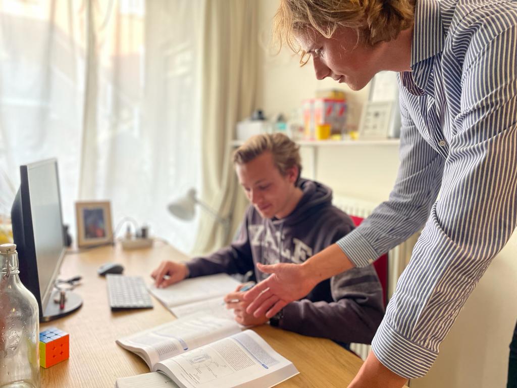 Sem geeft bijles aan een leerling thuis aan tafel